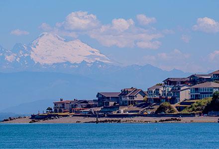 Mount Baker background with Camano Island beachfront houses in foreground